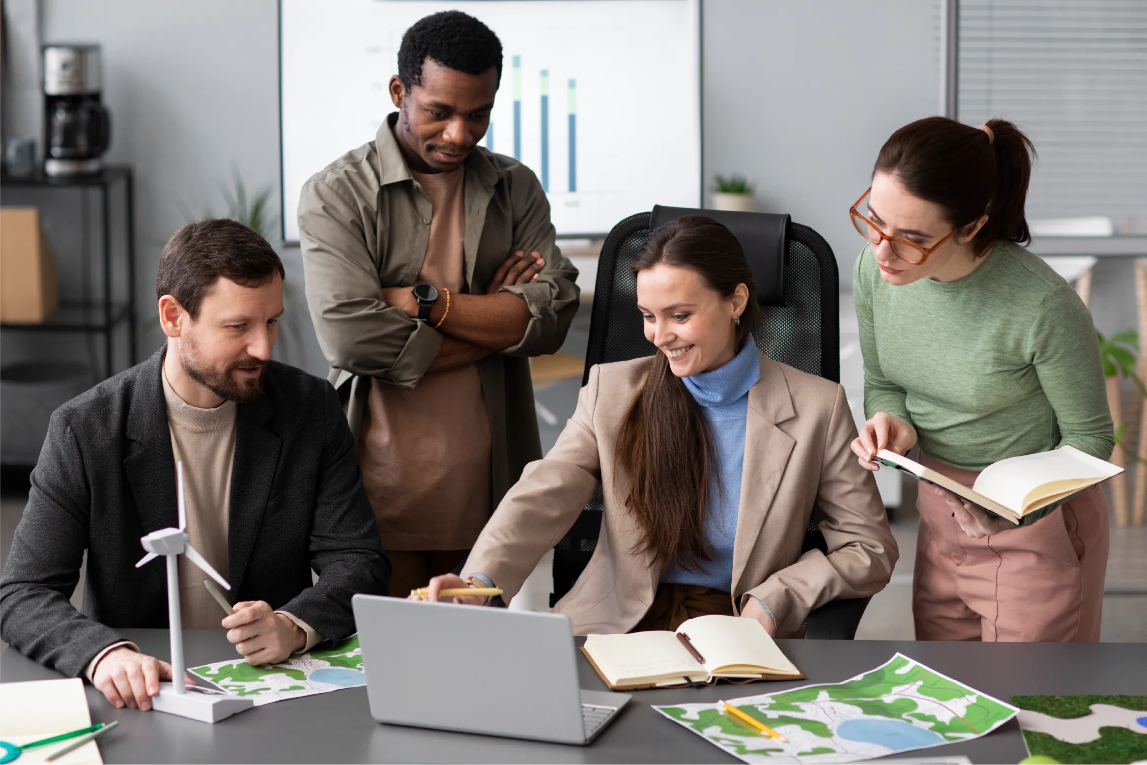 Equipo de trabajo revisando mapas y datos en un computador portátil